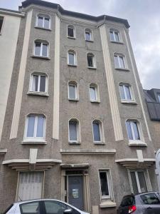 a large brick building with white windows on a street at Appartement Rousseau F2 in Montrouge