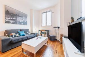 a living room with a couch and a coffee table at Appartement Rousseau F2 in Montrouge