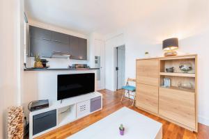 a living room with a flat screen tv on a wall at Appartement Rousseau F2 in Montrouge