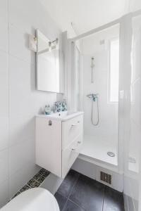 a white bathroom with a sink and a shower at Appartement Rousseau F2 in Montrouge