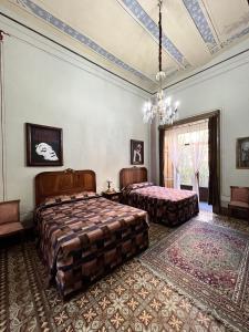 a bedroom with two beds and a chandelier at Hotel Boutique Casa de la Palma in Puebla