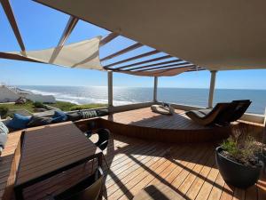 um deque de madeira com uma mesa e um guarda-chuva em NEW! Feel the Ocean Design Apartment em Pataias
