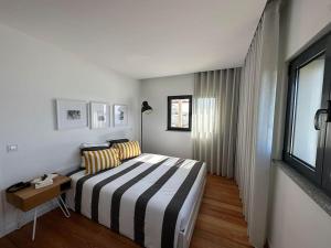 um quarto de hotel com uma cama e uma janela em NEW! Feel the Ocean Design Apartment em Pataias