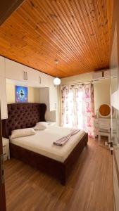 ein Schlafzimmer mit einem großen Bett und einer Holzdecke in der Unterkunft July Seaview Apartments in Sarandë + 62 Fotos
