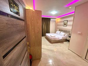 una camera con letto e una porta con luci viola di Pyramids Nun INN a Il Cairo