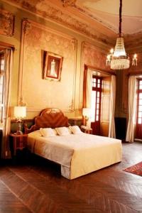 a bedroom with a bed and a chandelier at Hotel Boutique Casa de la Palma in Puebla