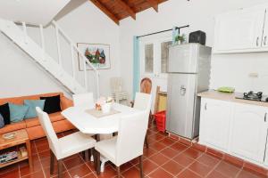 cocina y sala de estar con mesa y nevera en Villa Vacacional, Playa Pascual, en Santa Bárbara de Samaná