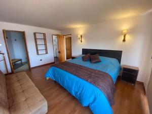 a bedroom with a blue bed and a couch at Casa con vista al mar en Caldera in Caldera