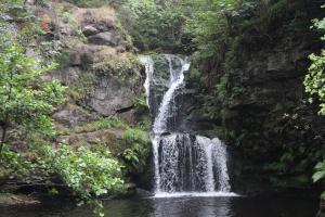 a waterfall on the side of a rock wall at No.46, comfortable 2 bedroom property in Rothes