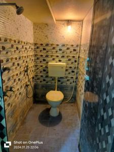 a bathroom with a toilet and a wall of wine bottles at SS GUEST HOUSE & PG in Kumbakonam