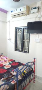 a room with a bed and a window at SS GUEST HOUSE & PG in Kumbakonam
