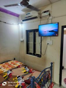 a room with a bed and a flat screen tv at SS GUEST HOUSE & PG in Kumbakonam