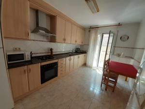 a kitchen with wooden cabinets and a stove top oven at Casa URIN in Almenar