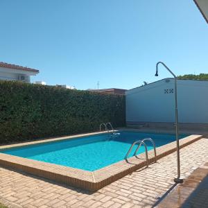 una piscina en un patio de ladrillo con un poste de luz en Hispalis villa en Matalascañas, en Matalascañas