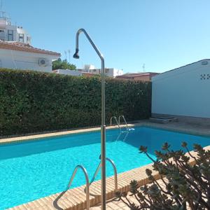 a swimming pool with a light pole next to a building at Hispalis villa en Matalascañas in Matalascañas