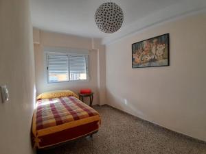 a bedroom with a bed and a pendant light at LAS 4 ESTACIONES in Elda