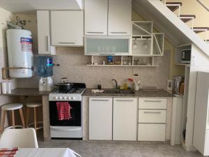 a kitchen with white cabinets and a stove at Duplex Marea Baja in Playa Unión