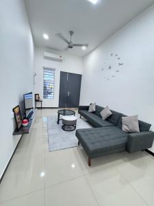 uma sala de estar com um sofá e uma mesa em The Moment Homestay # WIFI TV Washer em Taiping