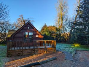 a small cabin with a fence in the yard at Epona 8 - Hot Tub-Perth-Pets-Luxury in Perth