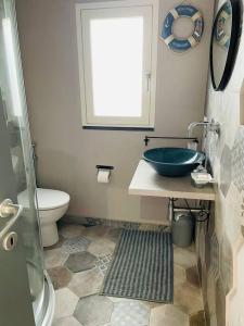 a bathroom with a blue sink and a toilet at Bluehouse ( 2 piani ) in Portopalo