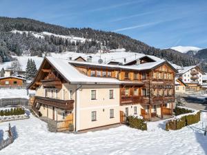 a home in the mountains with snow on the ground at Hirschenhof in Dobbiaco