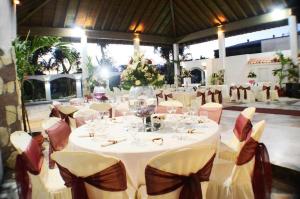 Hotel Tropicana Santo Domingo في La Viva: إعداد طاولة لحضور حفل زفاف مع كؤوس النبيذ