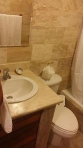 a bathroom with a white sink and a toilet at Hotel Tropicana Santo Domingo in La Viva