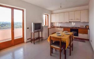 eine Küche mit einem Tisch und einem TV in der Unterkunft 2 Bedroom Gorgeous Apartment In Badolato Marina in Badolato