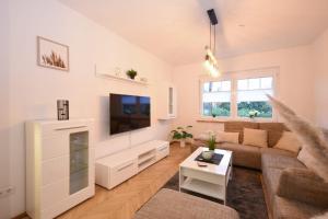 a living room with a couch and a tv at Ferienhaus Auszeit in Westoverledingen