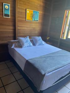 um quarto com uma cama grande e lençóis azuis em Chalé Rústico com piscina em São Gabriel