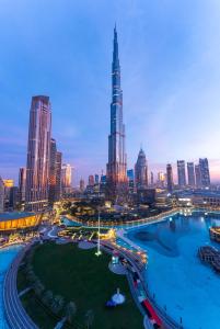 a city skyline at night with a river and buildings at Spectacular Burj & Fountain View - Luxurious 3 Bedrooms & Maids room - The Residences in Dubai