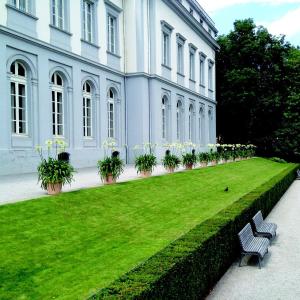 a bench in front of a building with a green lawn at 3 Zimmer 6 Betten Renoviert in Koblenz