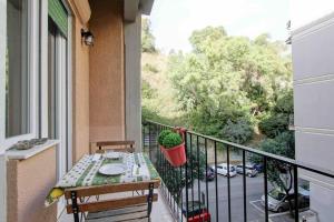 balcón con mesa y vistas al jardín en AMF Vatican Domus en Roma
