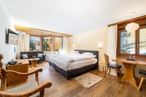 1 dormitorio con 1 cama y escritorio en una habitación en Hotel Allalin, en Saas-Fee