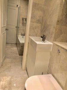 a bathroom with a white toilet and a sink at Chelsea in London