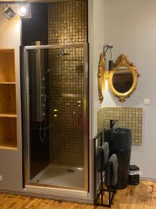 ducha con puerta de cristal y espejo en À HOME LOVE-SPA, le plus luxueux parmi nos 2 établissements, en Montluel