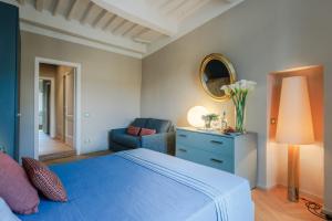 a bedroom with a blue bed with a blue dresser and a mirror at Casa Pino 2 bedrooms 2 bathrooms contemporary apar in Lucca