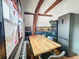 凱澤貝爾的住宿－Le Gite du Kaiser，一个带木桌和椅子的小厨房