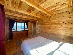 - une chambre avec un lit dans une pièce en bois dans l'établissement Naylakonak-2, à Cayeli