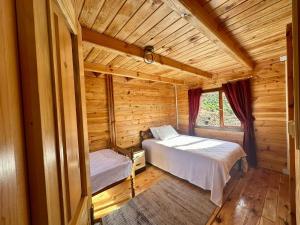 - une chambre avec 2 lits dans une cabane en rondins dans l'établissement Naylakonak-2, à Cayeli