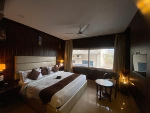 a bedroom with a large bed and a television at MJ Hills Rishikesh in Rishīkesh