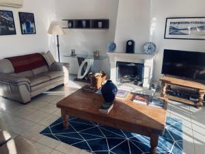 a living room with a coffee table and a fireplace at Modern Two Bedroom Poolside Townhouse in Budens