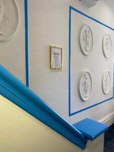 une chambre avec des plaques sur le mur et une étagère bleue dans l'établissement The New Athena Hotel, à Blackpool
