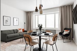 Prime Apartments Pori Central في بوري: غرفة معيشة مع طاولة وكراسي