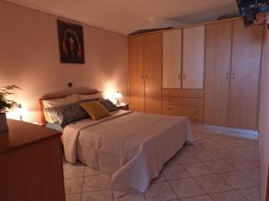 um quarto com uma cama, uma cómoda e armários em Kalimera Apartments em Kokkari