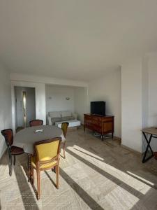 un soggiorno con tavolo, sedie e divano di AGENCIA Appartement 2 pièces lumineux 5e a Cannes