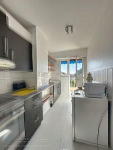 una grande cucina bianca con lavandino e finestra di AGENCIA Appartement 2 pièces lumineux 5e a Cannes