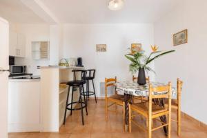 a kitchen and dining room with a table and chairs at Location 2 pièces sur EZE à 3km de MONACO (2) in Éze