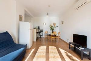 a living room with a refrigerator and a table with chairs at Location 2 pièces sur EZE à 3km de MONACO (2) in Éze