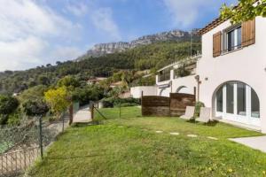 a white house with a hill in the background at Location 2 pièces sur EZE à 3km de MONACO (2) in Éze